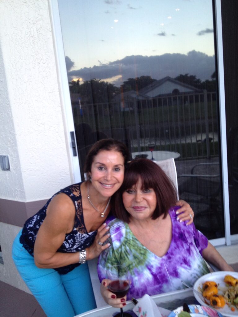 Carrie Morris poses with her mother, Anita Lymber, at an outdoor dining table.